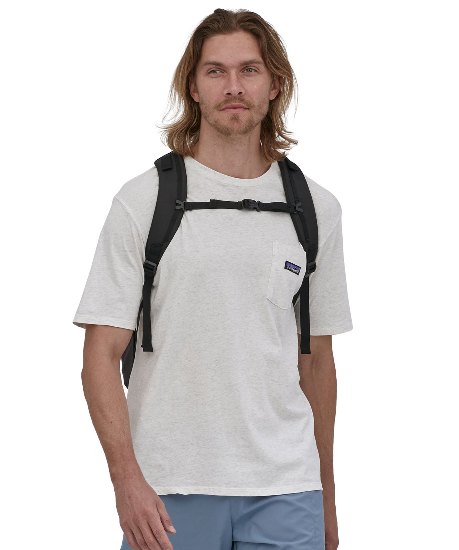 A person wearing the Patagonia Refugio Day Pack 30L Black, showing the sholder straps and the chest strap closed
