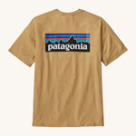 Patagonia Men's P-6 Logo Responsibili-Tee - Beeswax Tan. A dark yellow, short sleeve, organic cotton top with a Patagonia mountain range logo on the back