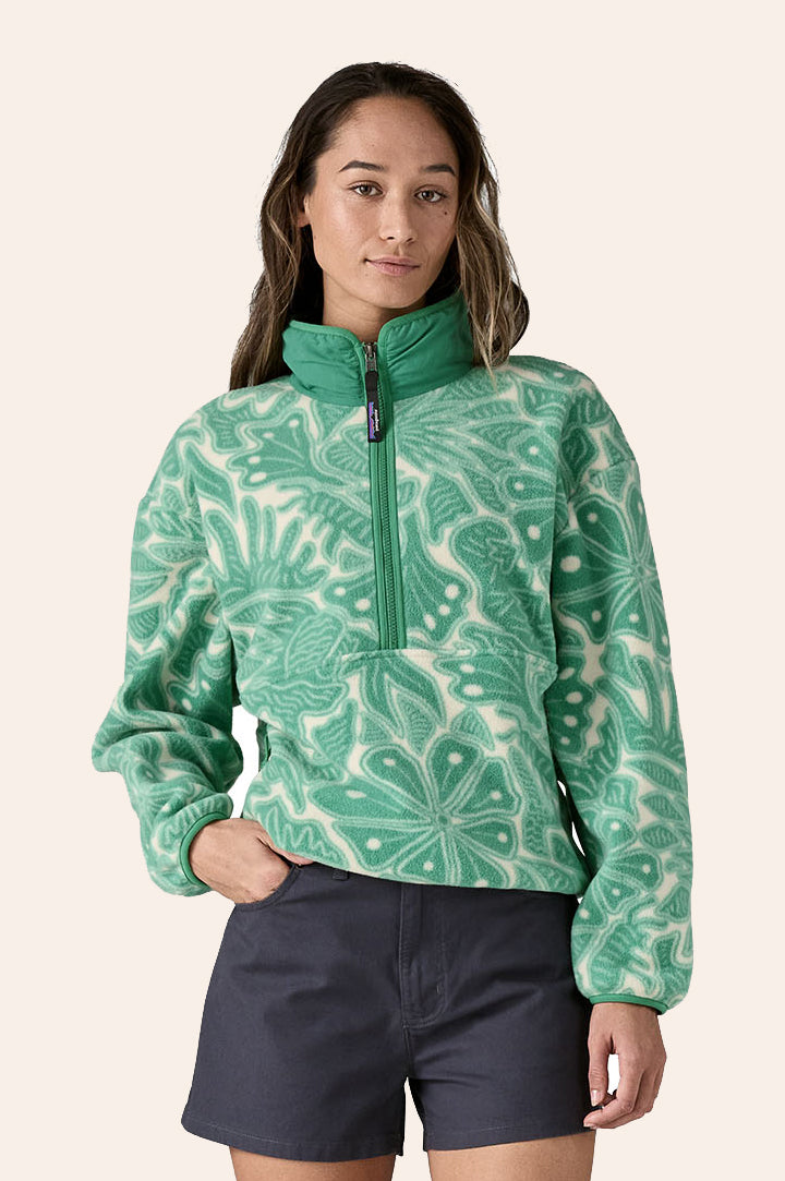 Woman wearing Patagonia Women's Synchilla Fleece Full-Zip Jacket in Bees and Flowers / Heartleaf Green. Made from 100% recycled polyester, with a large green left-chest zipped pocket. Elasticated cuffs and bottom hem.