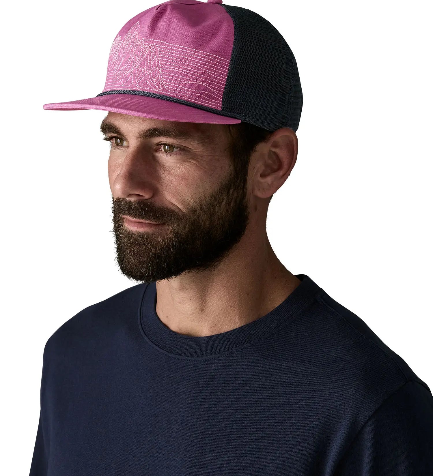 Man wearing Patagonia's airfarer cap in pink with blue mesh back panel.  Hat has a trucker style and wide brim