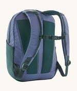 A reverse image of the Patagonia 24L current blue atom day pack in  showing the padded shoulder strap and dark green chest strap detail