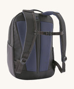 A reverse image of the Patagonia 24L smolder blue atom day pack in  showing the padded shoulder strap and pale black chest strap detail