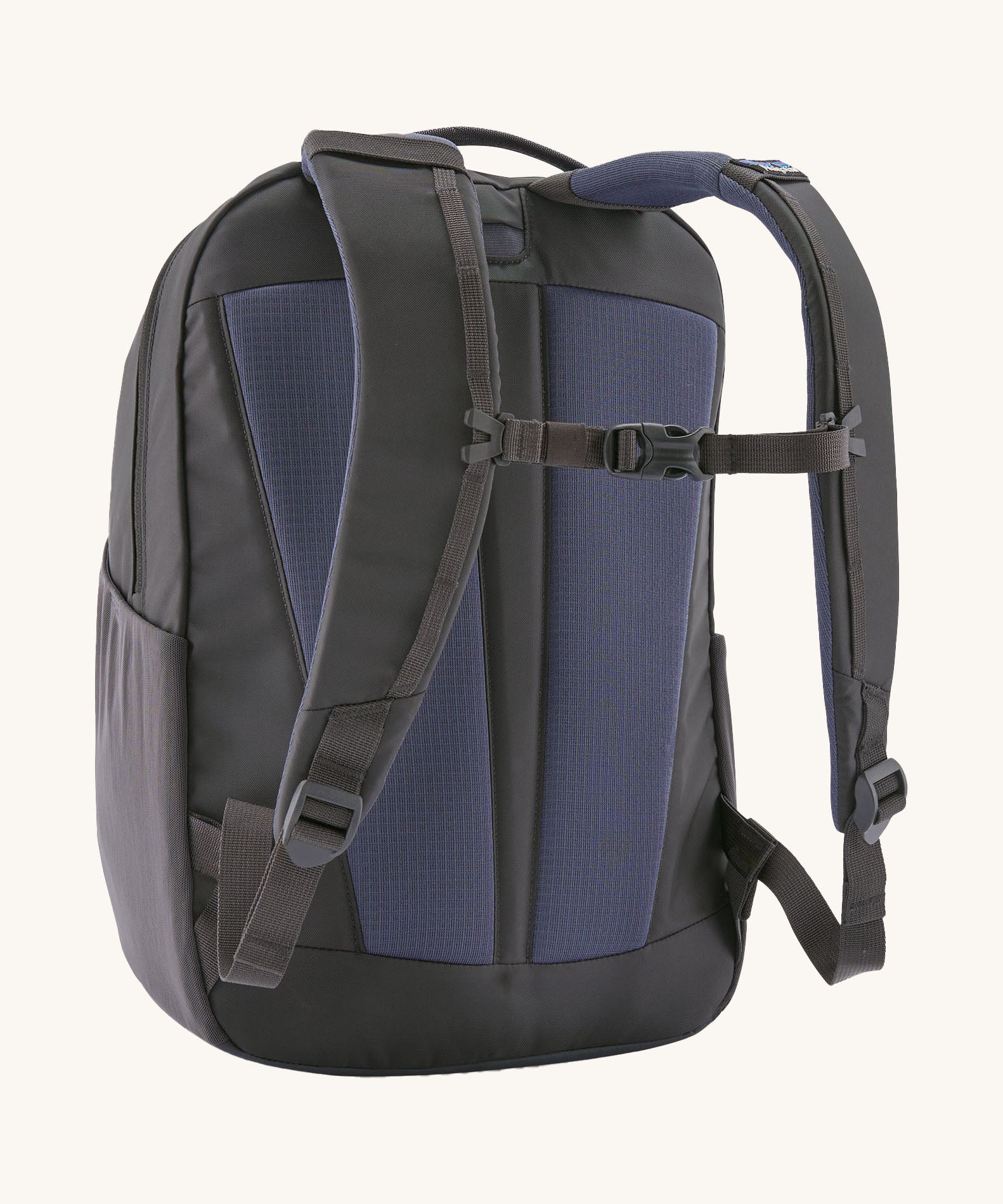A reverse image of the Patagonia 24L smolder blue atom day pack in  showing the padded shoulder strap and pale black chest strap detail