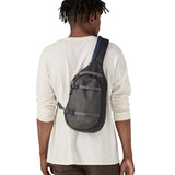 The back of a man wearing the Patagonia atom sling 8L bag in smolder blue available at Babipur.