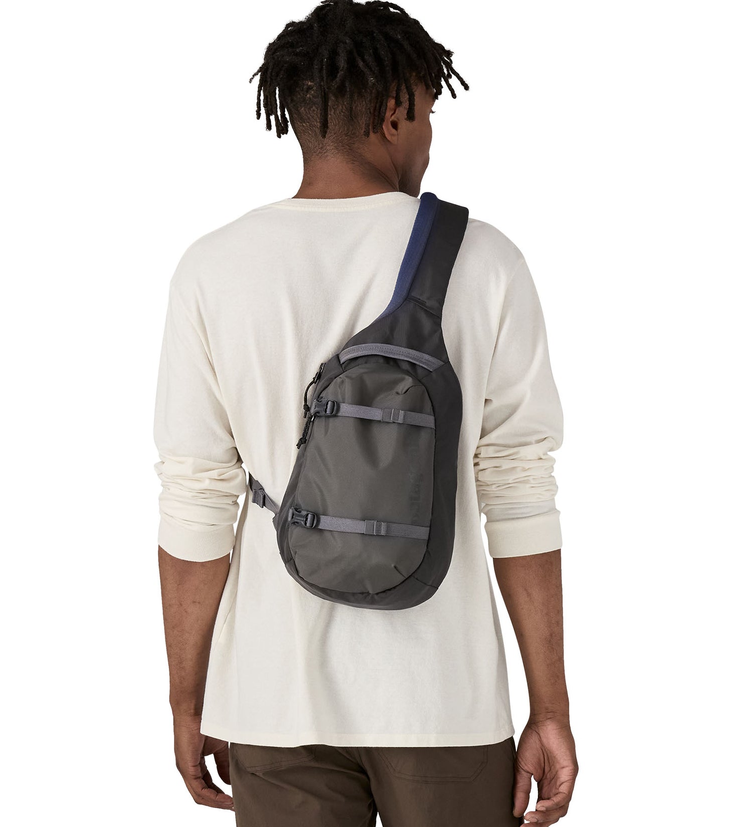 The back of a man wearing the Patagonia atom sling 8L bag in smolder blue available at Babipur.