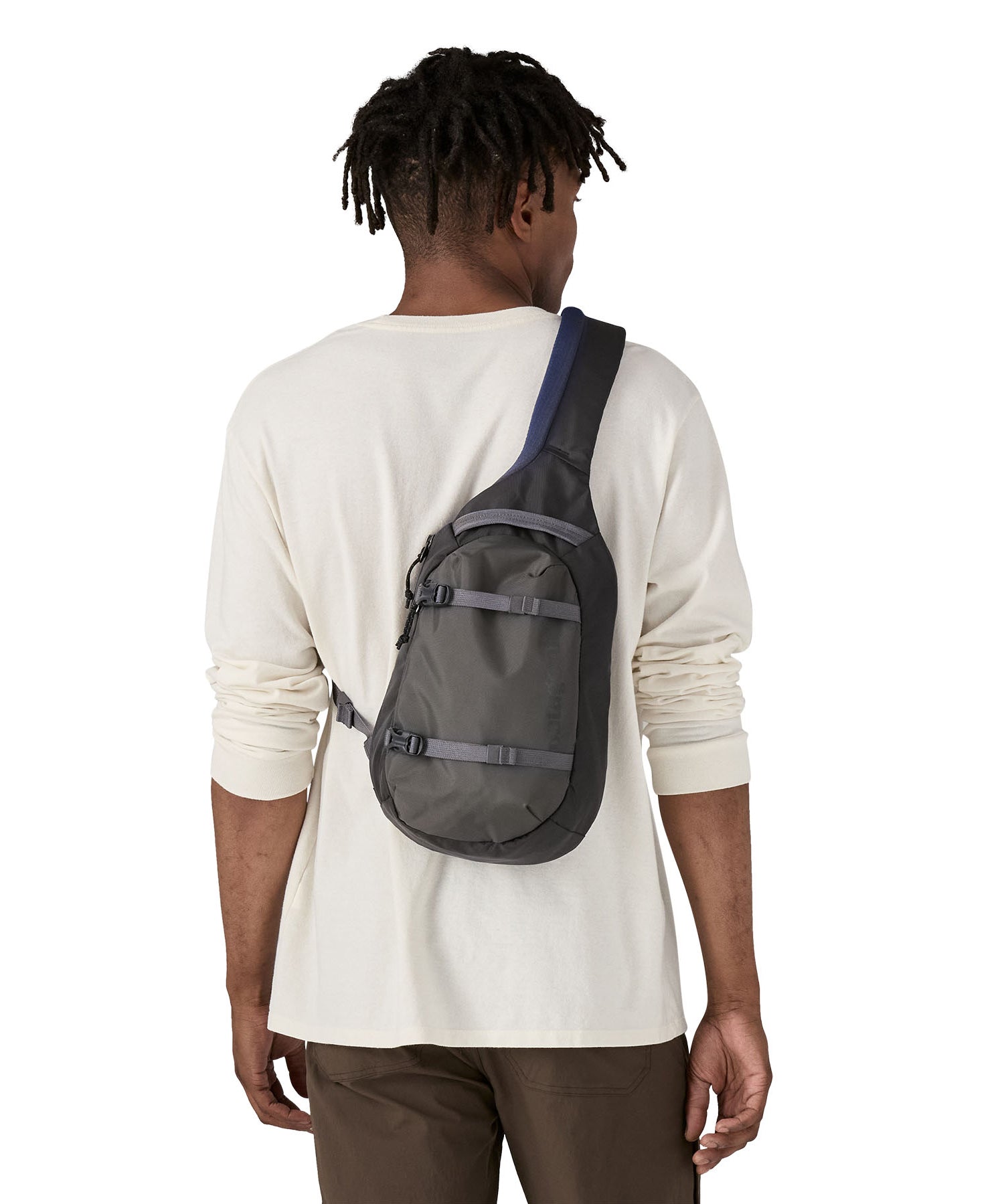The back of a man wearing the Patagonia atom sling 8L bag in smolder blue available at Babipur.