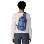 The back of a woman wearing the Patagonia atom 8 litre sling bag in current blue available at Babipur 