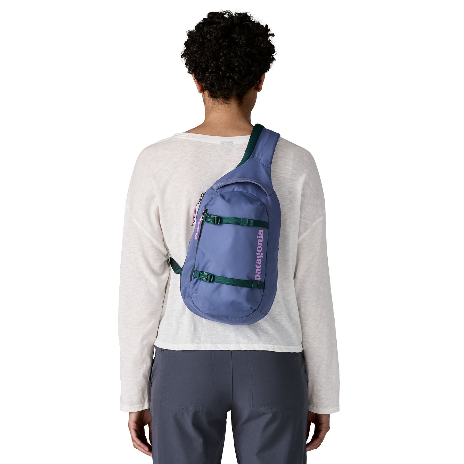 The back of a woman wearing the Patagonia atom 8 litre sling bag in current blue available at Babipur 