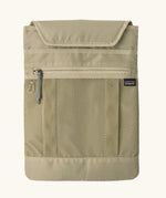 Extra laptop sleeve included with Patagonia atom 20 litre tote pack in light green showing extra zipped front pocket
