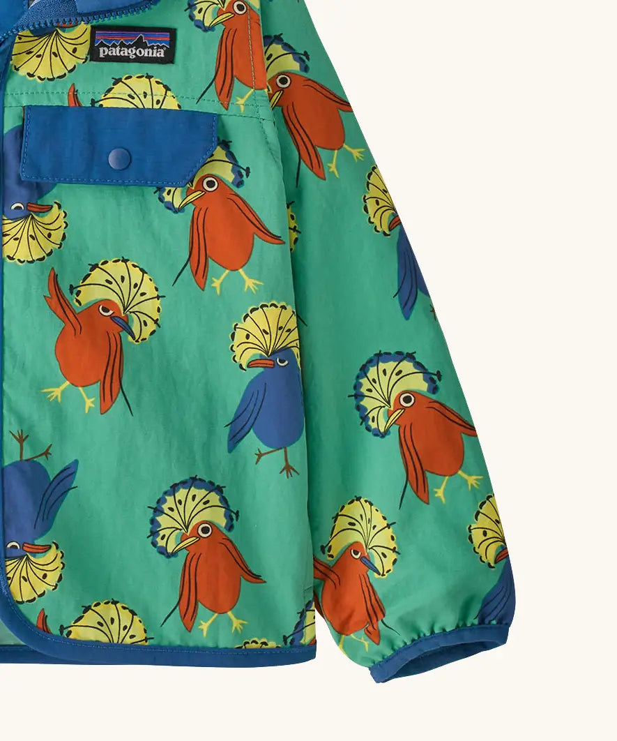 Close up of Patagonia baby baggies hooded jacket in green with repeating red and blue bird design. Shows blue hem and cuff trim