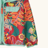 Close up of Patagonia red baby baggies hooded jacket with repeating abstract tropical pattern. Shows light blue hem and cuff trim
