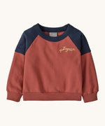 Patagonia Baby Crew Sweatshirt in wiggle fitz / potters red available at Babipur. A red and navy colourblock sweater with the brand name in a handwritten style stitched on the chest