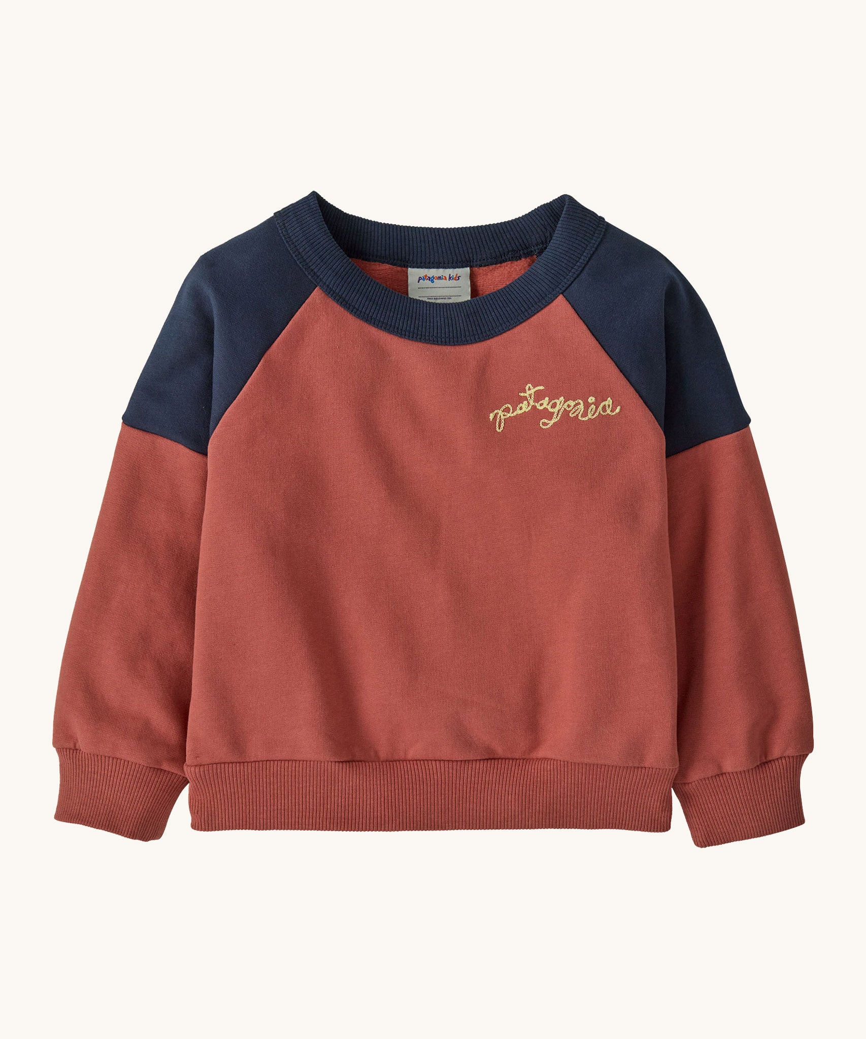 Patagonia Baby Crew Sweatshirt in wiggle fitz / potters red available at Babipur. A red and navy colourblock sweater with the brand name in a handwritten style stitched on the chest