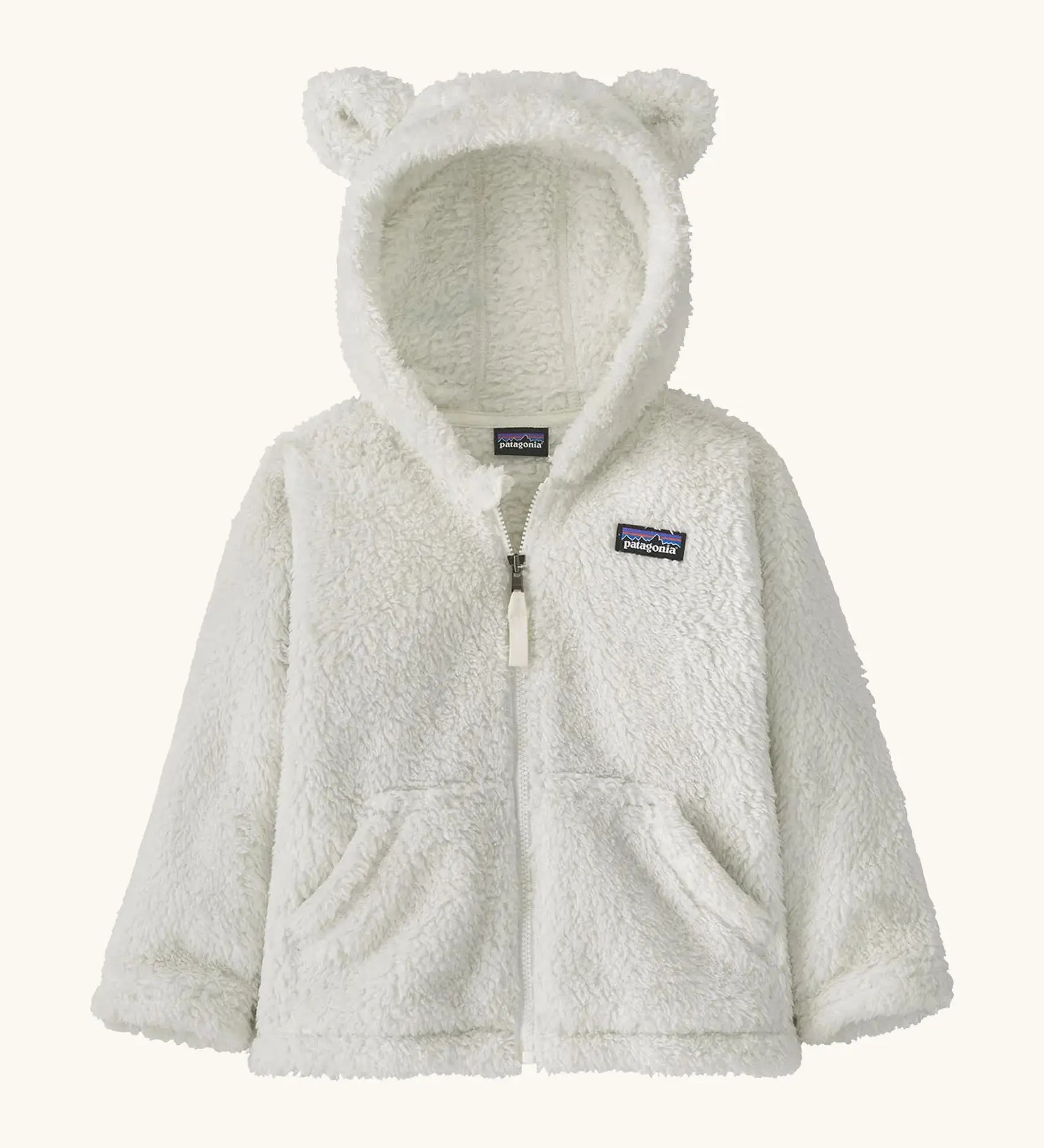 Patagonia Baby Furry Friends Hoody in birch white. Cream Fluffy hooded fleece with a full zip and pockets. Bear cub ears on the hood. Patagonia logo patch stitched on the front.