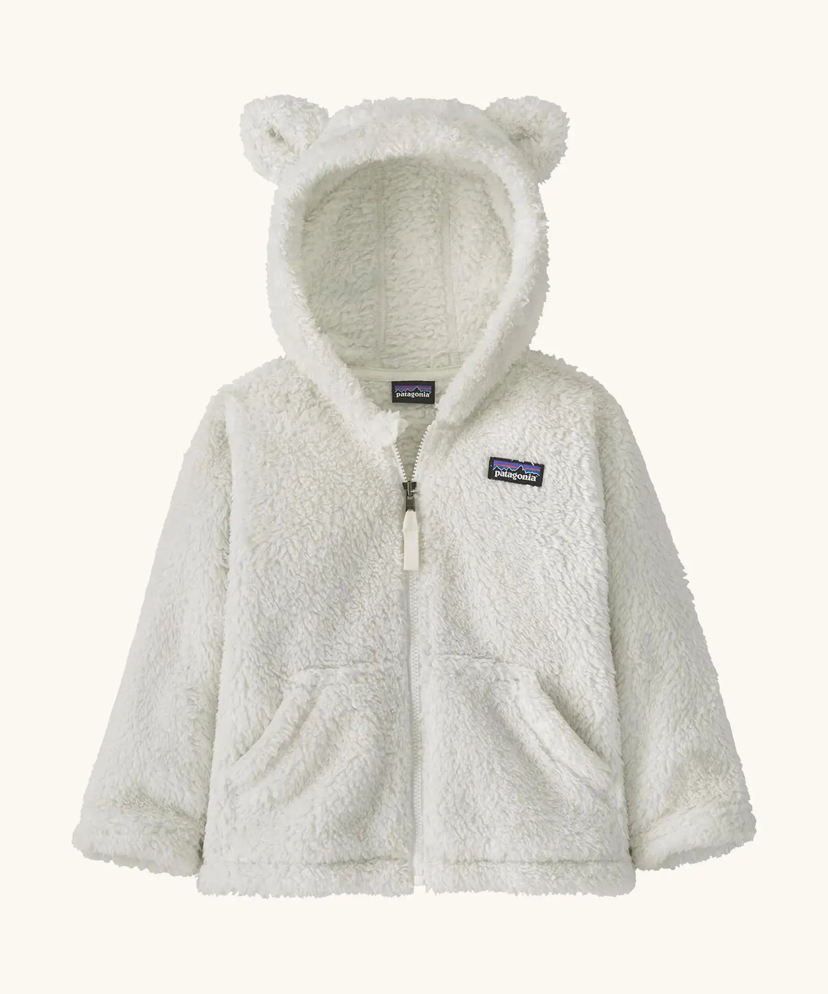 Patagonia Baby Furry Friends Hoody in birch white. Cream Fluffy hooded fleece with a full zip and pockets. Bear cub ears on the hood. Patagonia logo patch stitched on the front.