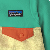 Close up of Patagonia little kids hooded micro d snap t jacket in yellow and green. Showing chest pocket with a green flap 