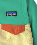 Close up of Patagonia little kids hooded micro d snap t jacket in yellow and green. Showing chest pocket with a green flap 