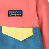 Close up of Patagonia little kids hooded micro d snap t jacket in blue and pink. Showing chest pocket with a yellow flap 