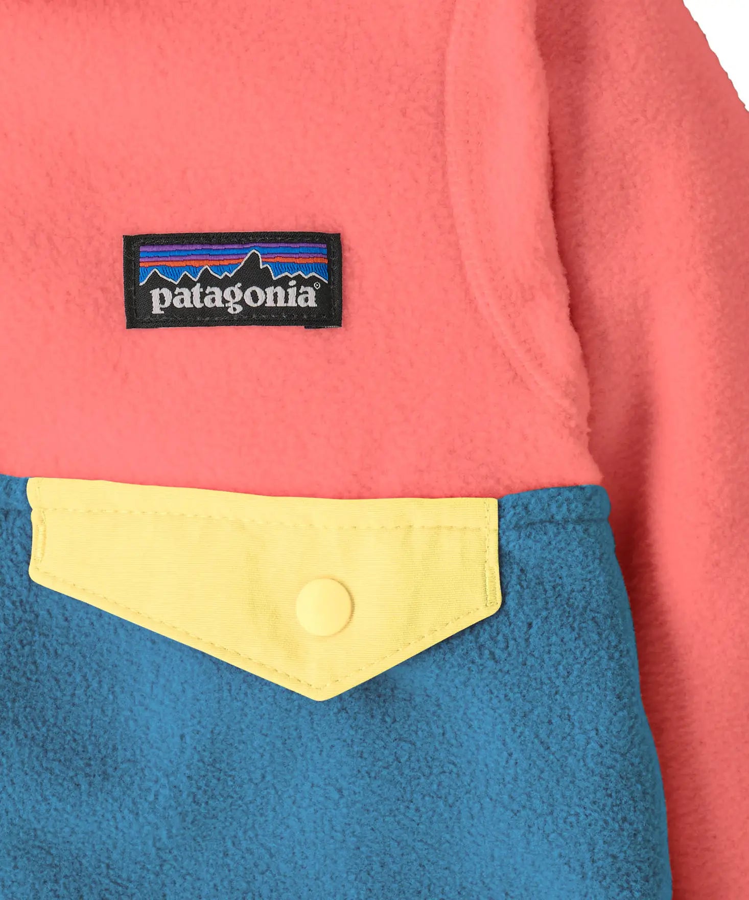 Close up of Patagonia little kids hooded micro d snap t jacket in blue and pink. Showing chest pocket with a yellow flap 