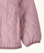 Close up of Patagonia's Little Kids Nano Puff Jacket  in pale purple showing the side pocket and a pink hem and cuff trim