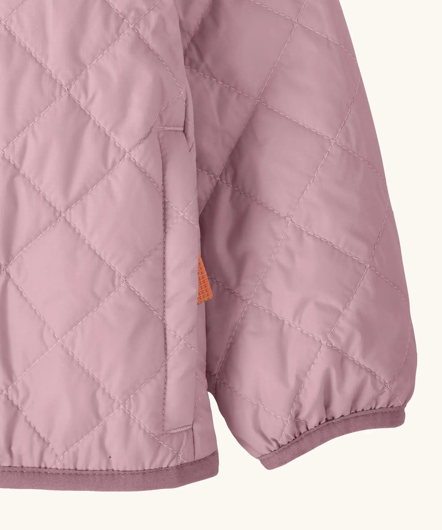 Close up of Patagonia's Little Kids Nano Puff Jacket  in pale purple showing the side pocket and a pink hem and cuff trim