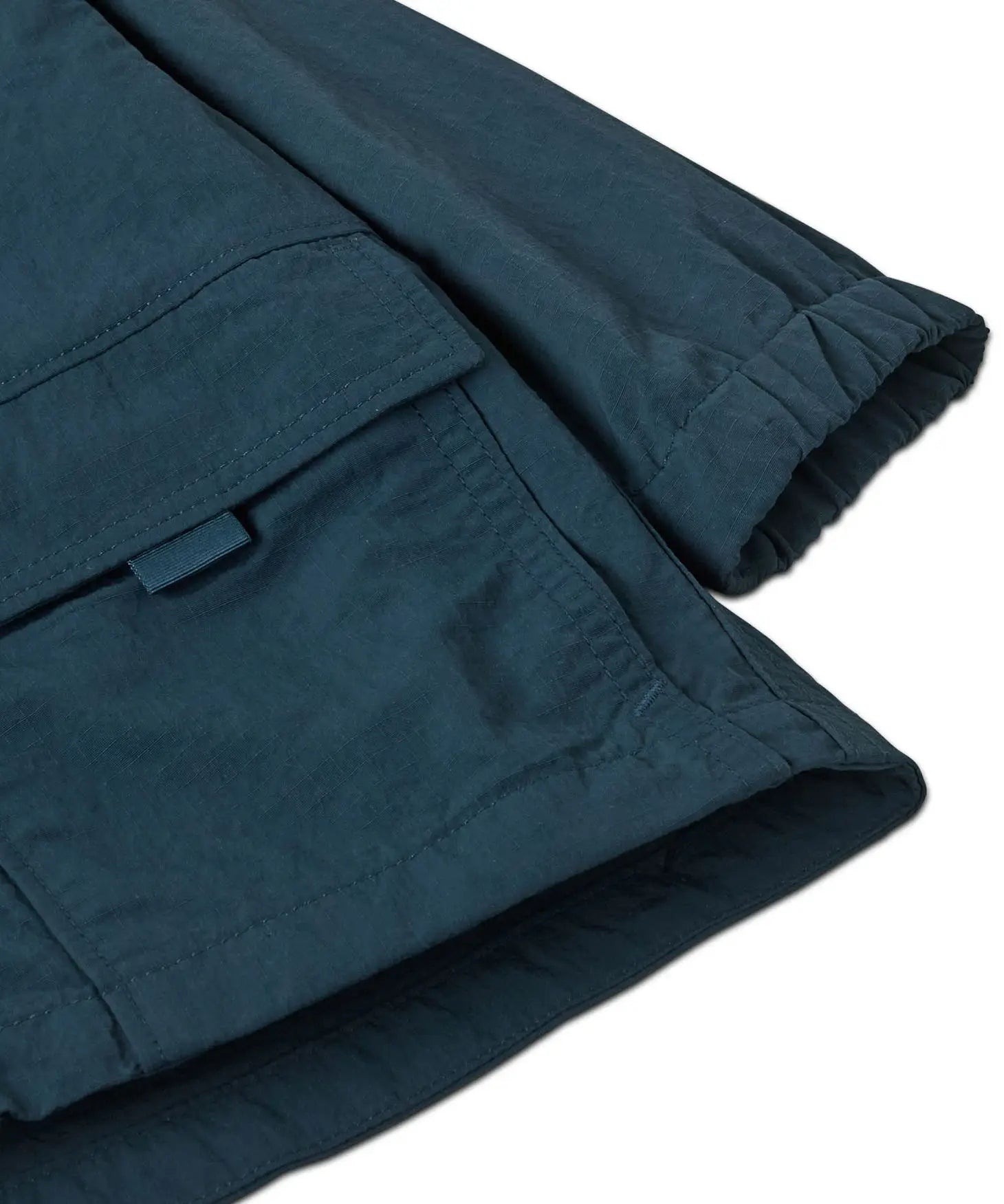 Close up of Patagonia's little kids recycled nylon outdoor everyday jacket in navy showing front velcro pocket and elasticated cuff