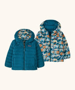 Patagonia baby reversible down hooded sweater jacket in glacial blue with a repeating playful seal design on the reverse. Features a full front zip and pockets