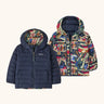 Patagonia baby reversible down hooded sweater jacket in new navy with a repeating colourful abstract design on the reverse. Features a full front zip and pockets