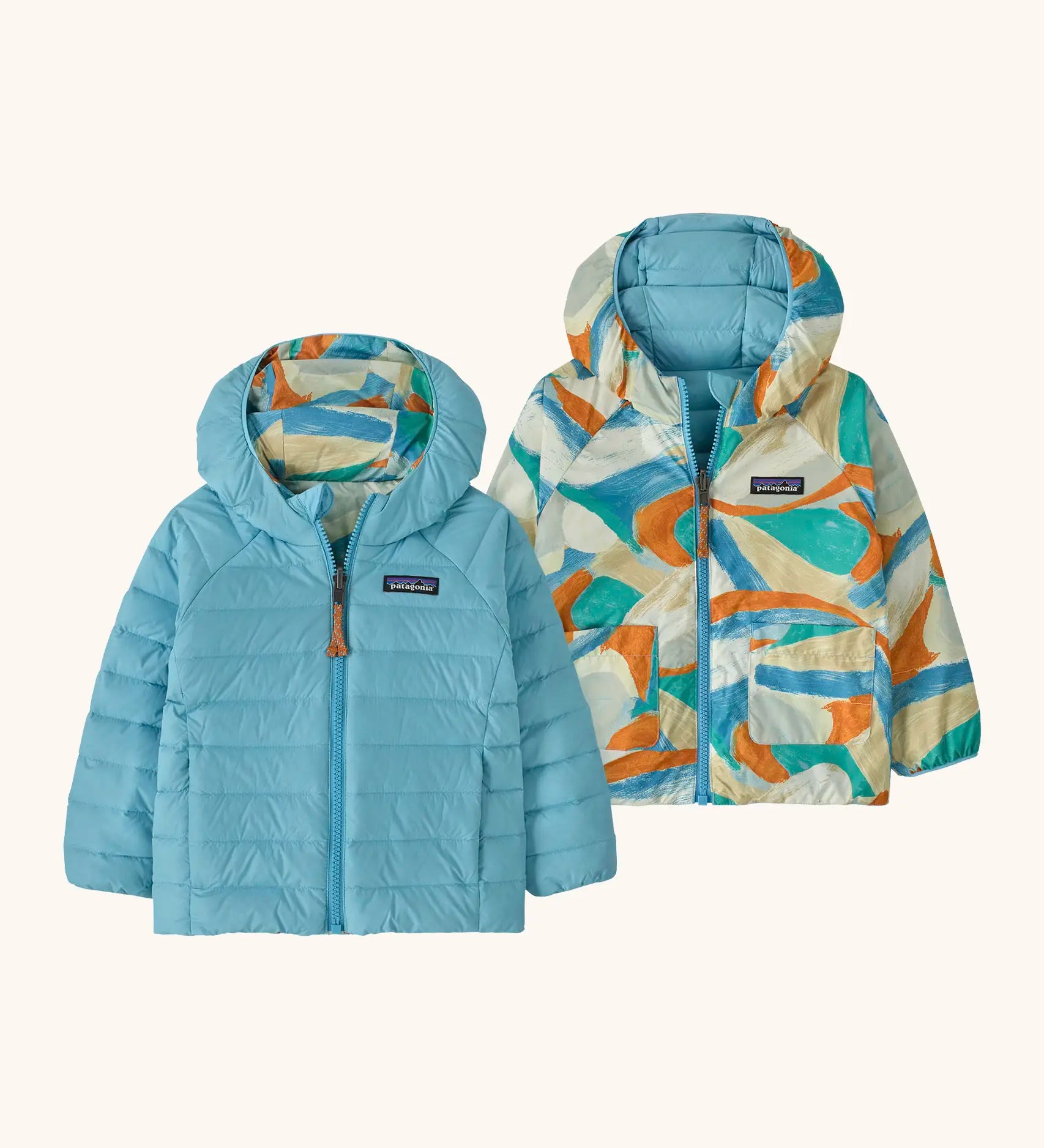 Patagonia baby reversible down hooded sweater jacket in bright blue with a abstract brushstroke design on the reverse. Features a full front zip and pockets