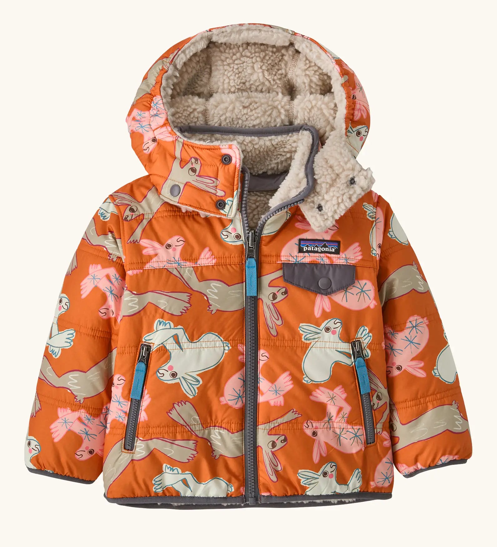 Patagonia reversible little kids tribbles hoody coat in orange with a repeating bunny design. Features a removable hood, chest and side pockets