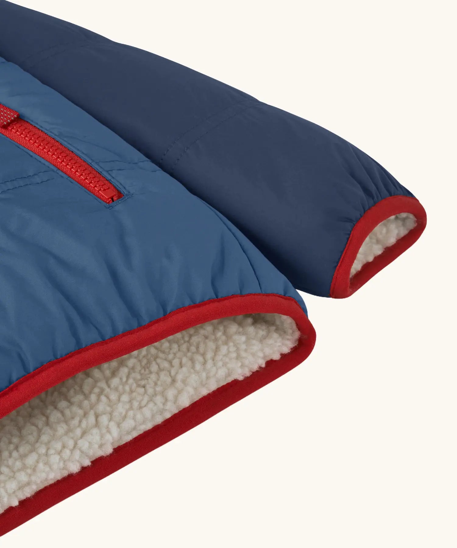 Back of Patagonia reversible little kids tribbles hoody in blue showing close up of the red trim on the cuff, hem and fleeec inner liner for warmth.