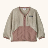 Patagonia baby fleece shearlings jacket in beige with pale pink trim. Features a full length zip and front pockets