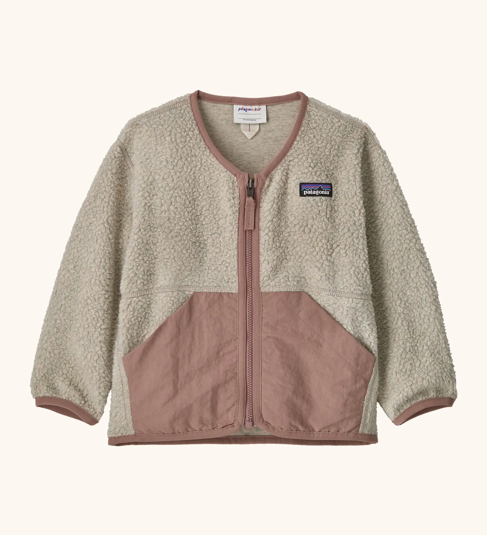Patagonia baby fleece shearlings jacket in beige with pale pink trim. Features a full length zip and front pockets