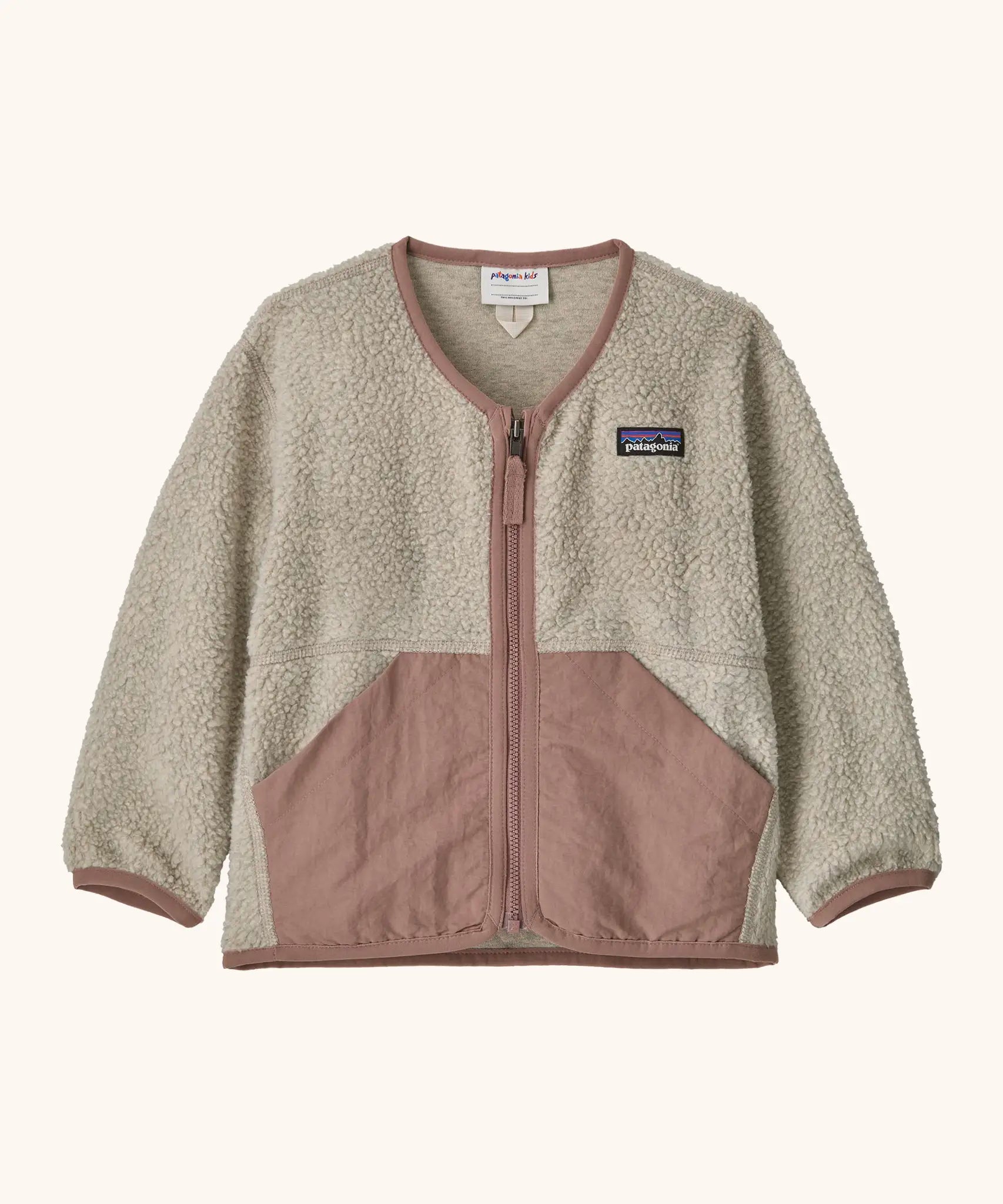 Patagonia baby fleece shearlings jacket in beige with pale pink trim. Features a full length zip and front pockets