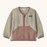 Patagonia baby fleece shearlings jacket in beige with pale pink trim. Features a full length zip and front pockets