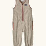 Patagonia baby fleeced shearlings overalls in beige with pale pink trim. Features a half length zip and side pockets
