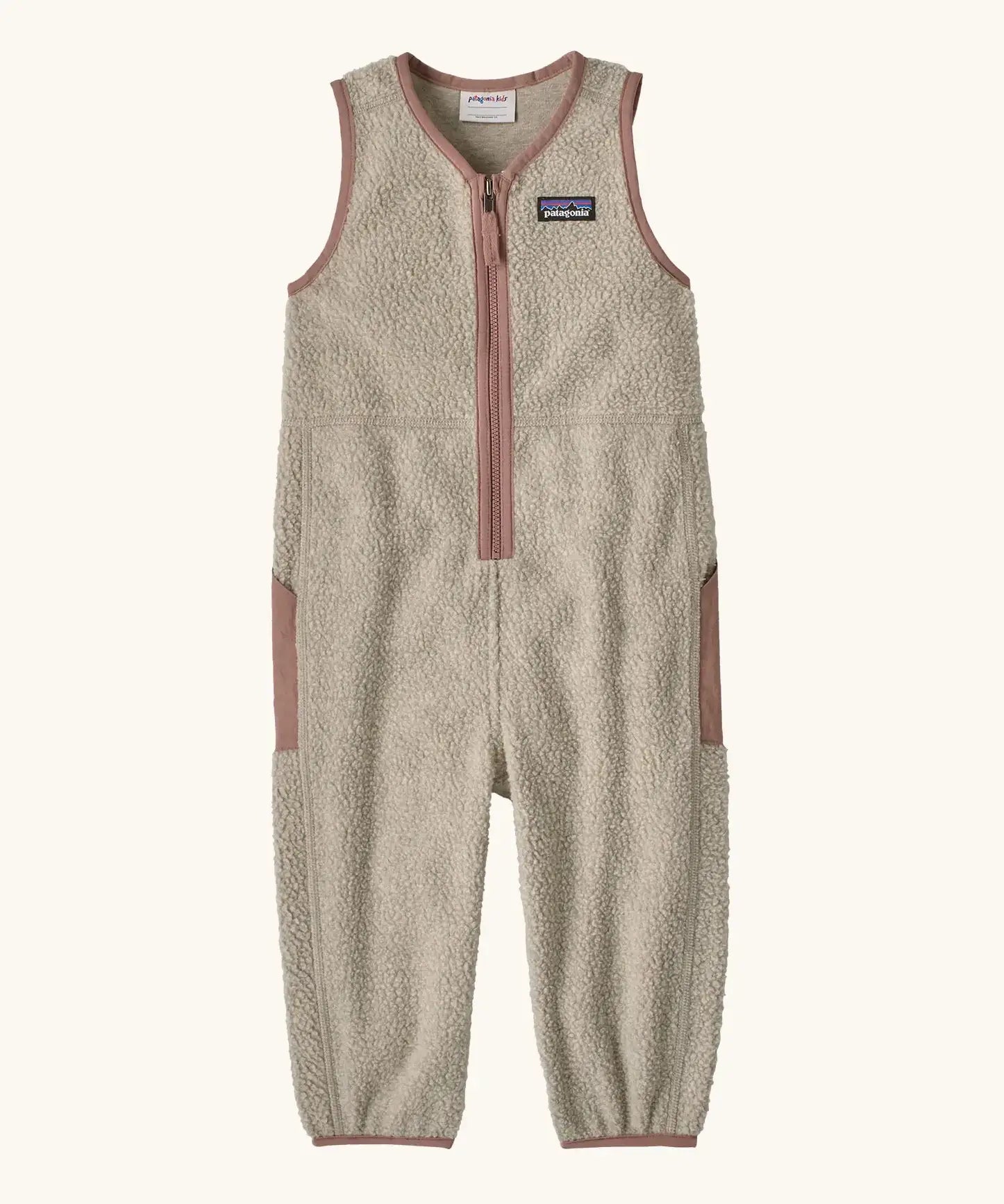 Patagonia baby fleeced shearlings overalls in beige with pale pink trim. Features a half length zip and side pockets