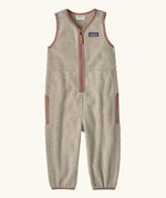 Patagonia baby fleeced shearlings overalls in beige with pale pink trim. Features a half length zip and side pockets