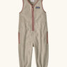 Patagonia baby fleeced shearlings overalls in beige with pale pink trim. Features a half length zip and side pockets