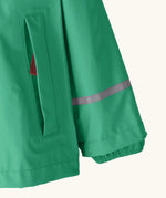 Patagonia little kids torrentshell 3 layer rain jacket in green showing side pocket and reflective strip around arm