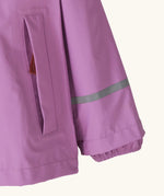 Patagonia little kids torrentshell 3 layer rain jacket in bright purple showing side pocket and reflective strip around arm