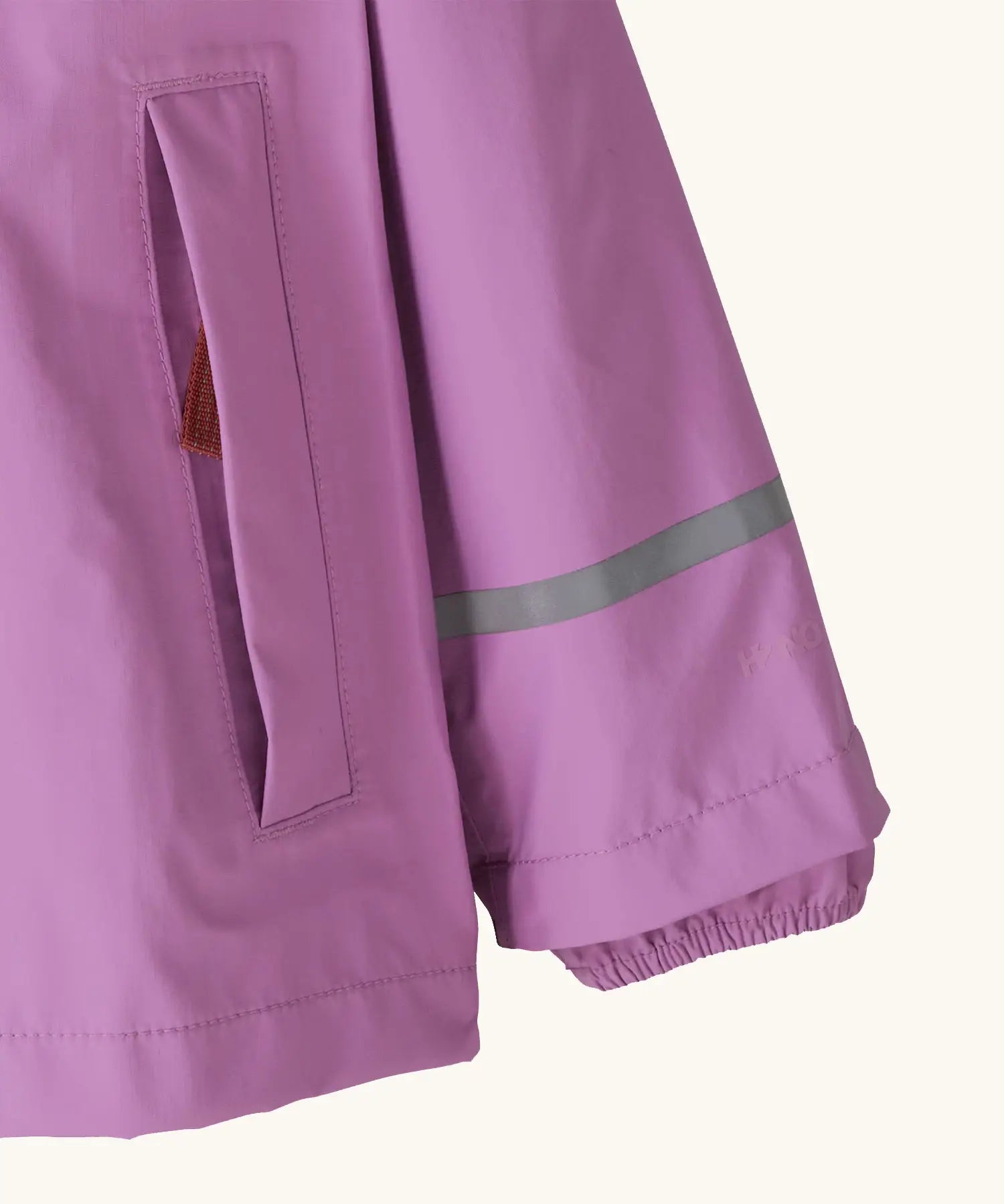 Patagonia little kids torrentshell 3 layer rain jacket in bright purple showing side pocket and reflective strip around arm
