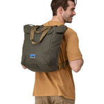 A person wearing the Patagonia Waxed Canvas Tote Pack Basin Green on their back