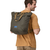 A person wearing the Patagonia Waxed Canvas Tote Pack Basin Green on their back