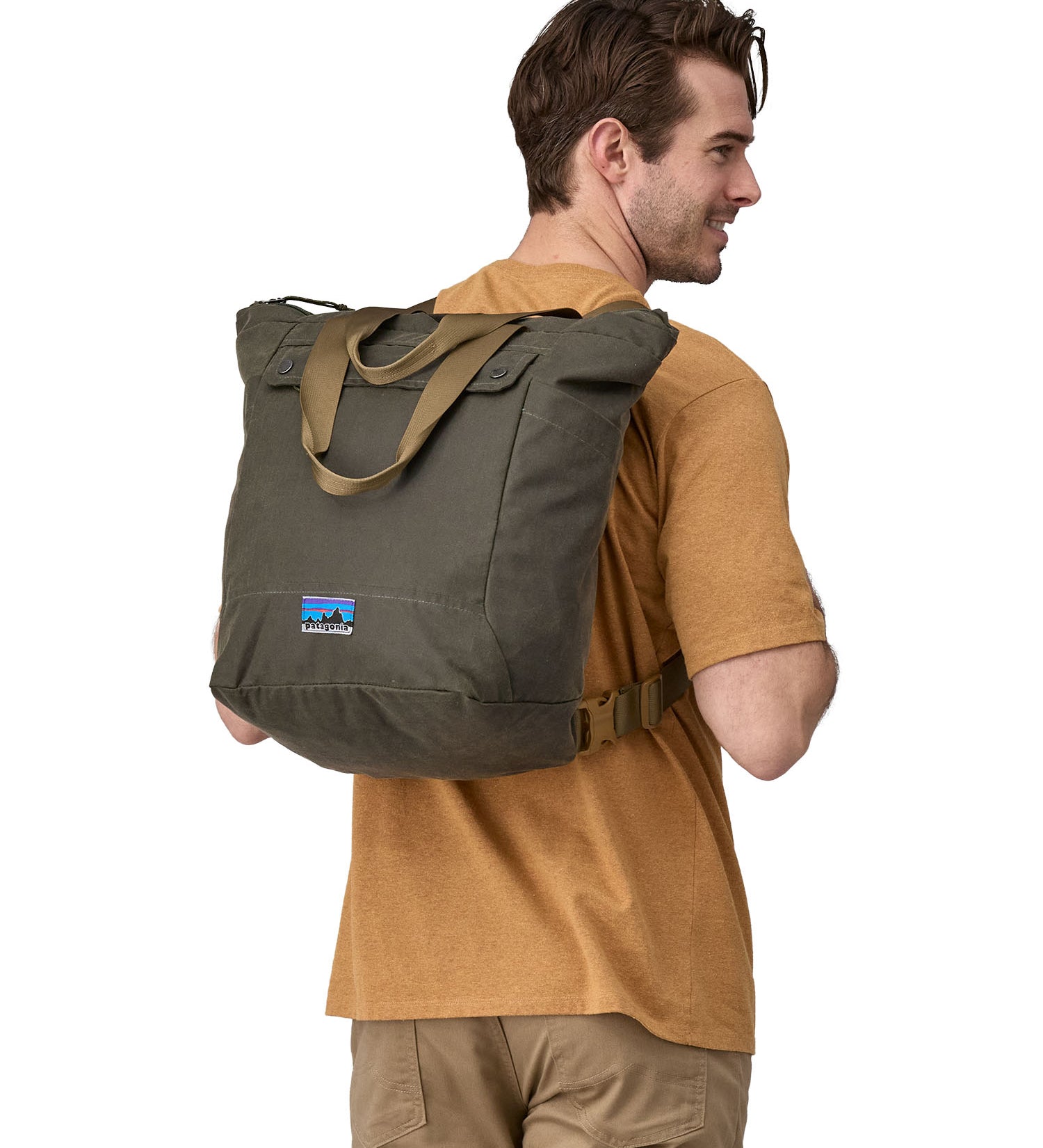 A person wearing the Patagonia Waxed Canvas Tote Pack Basin Green on their back