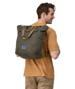 A person wearing the Patagonia Waxed Canvas Tote Pack Basin Green on their back