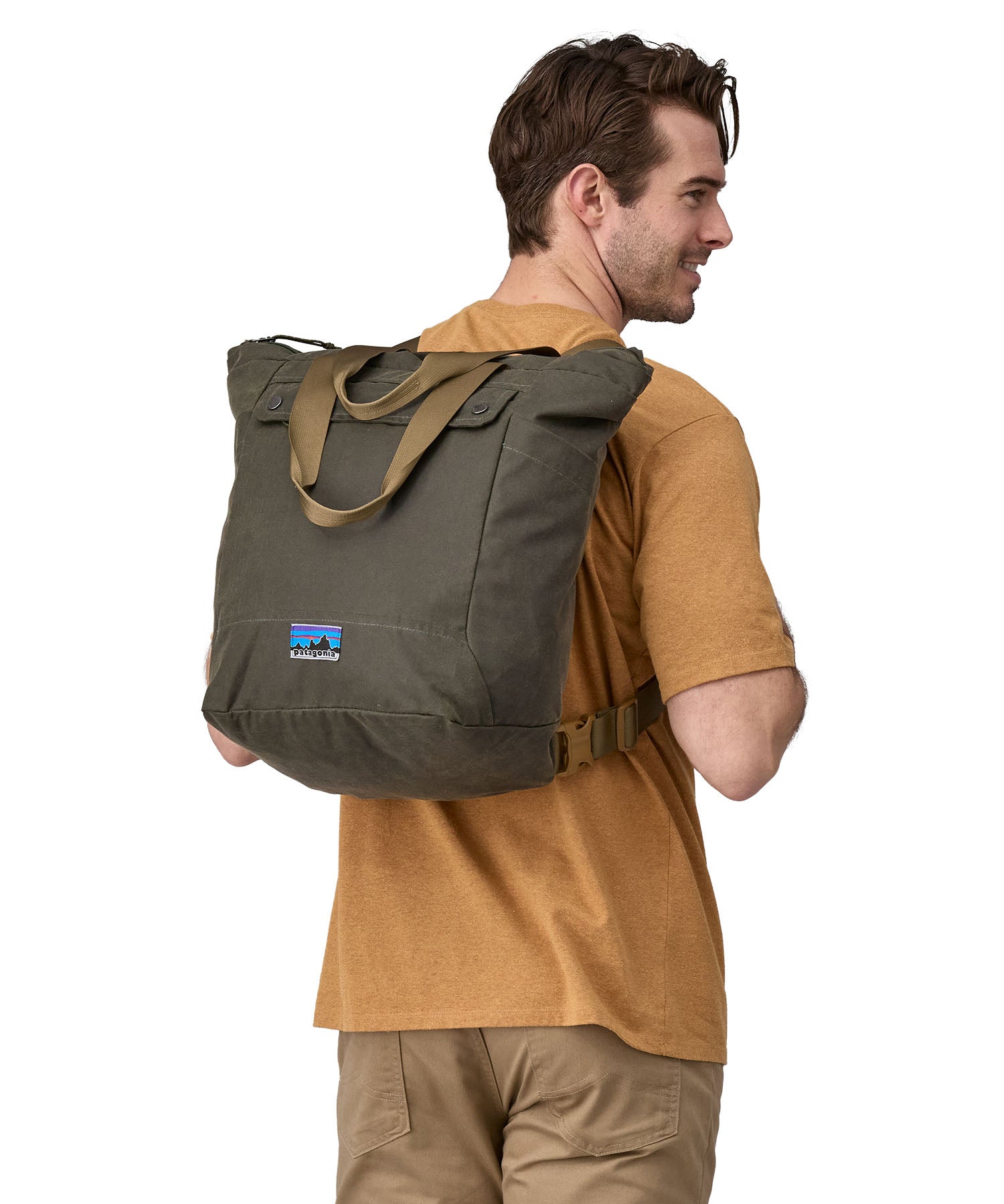 A person wearing the Patagonia Waxed Canvas Tote Pack Basin Green on their back