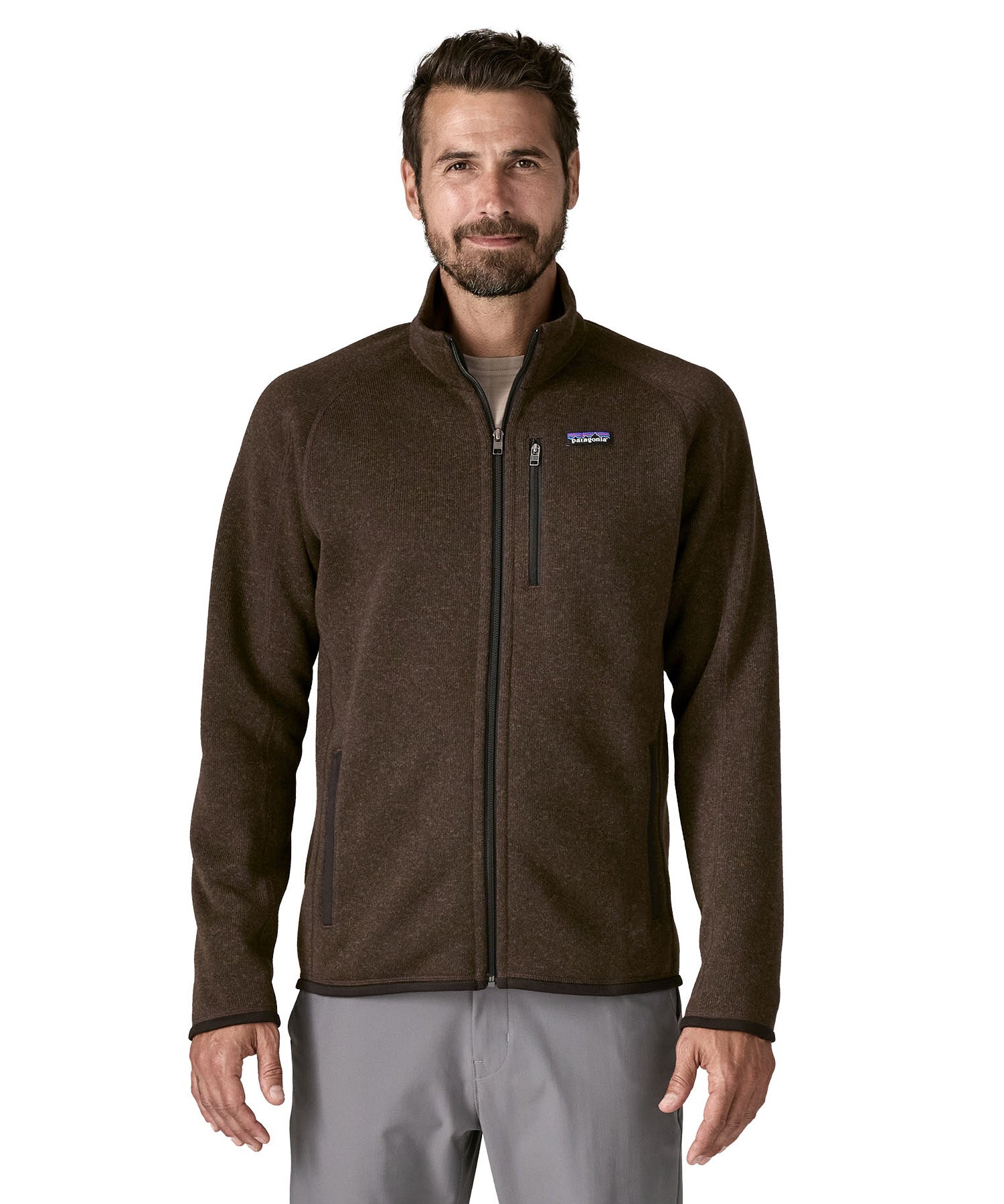A man wearing the Patagonia men's better sweater in otter brown available at Babipur. A lightweight fleece style jacket with full length zip, 2 side pockets, a chest pocket and features the brand logo patch stitched on the left chest 