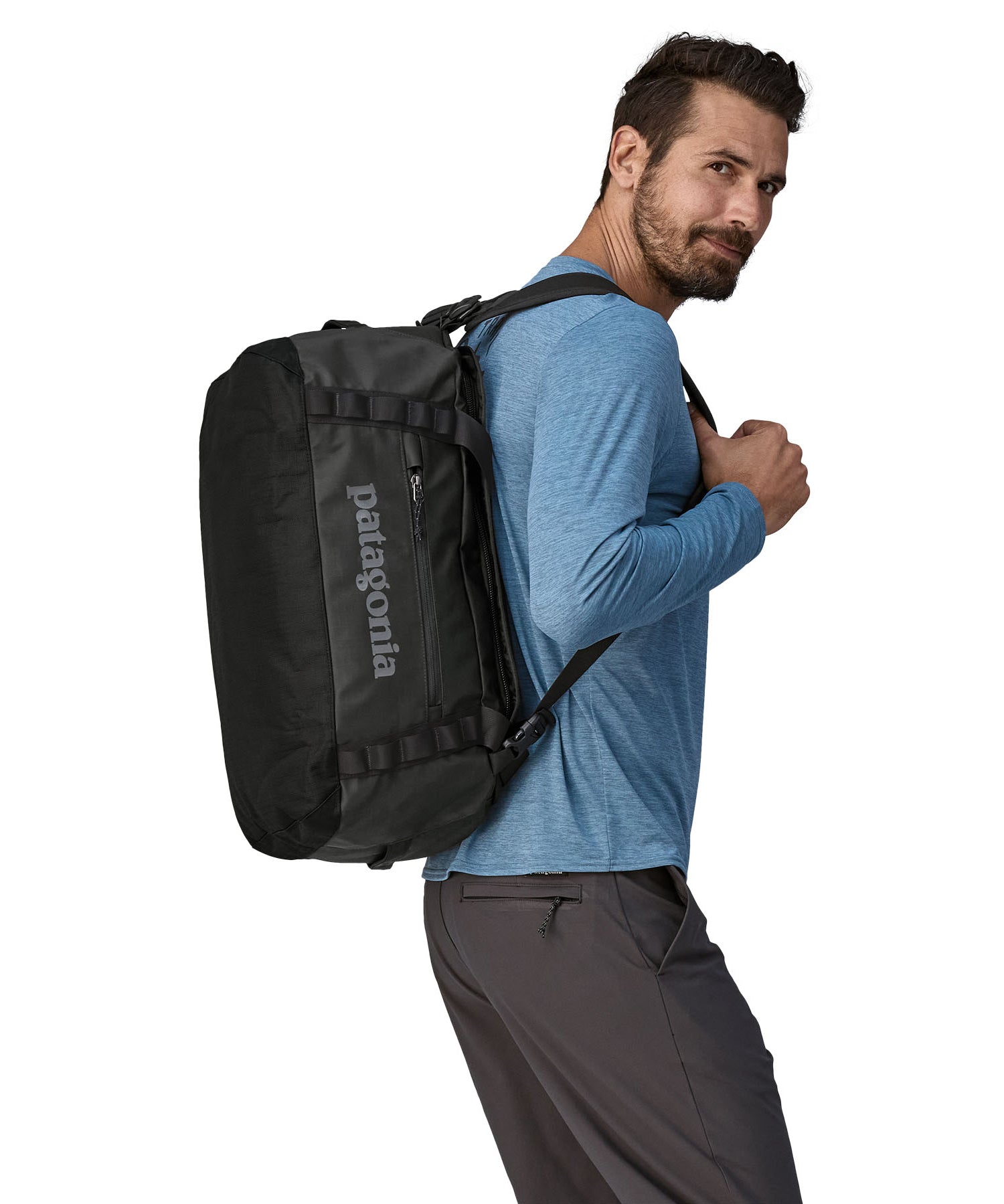 A person carrying the Patagonia Black Hole Duffel 40L on their shoulder using the shoulder straps