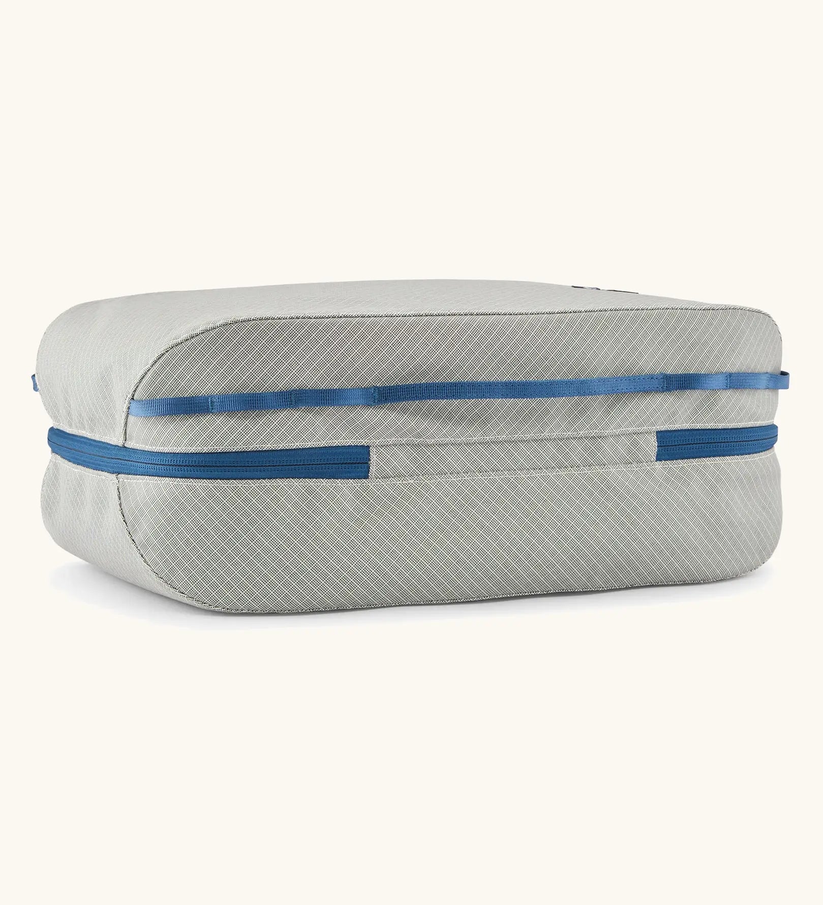 Underside of the Patagonia black hole 14 litre cube bag in light grey showing the blue zip running underneath 